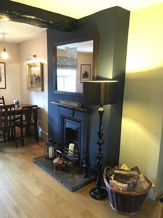 The fireplace with a basket of wood beside it